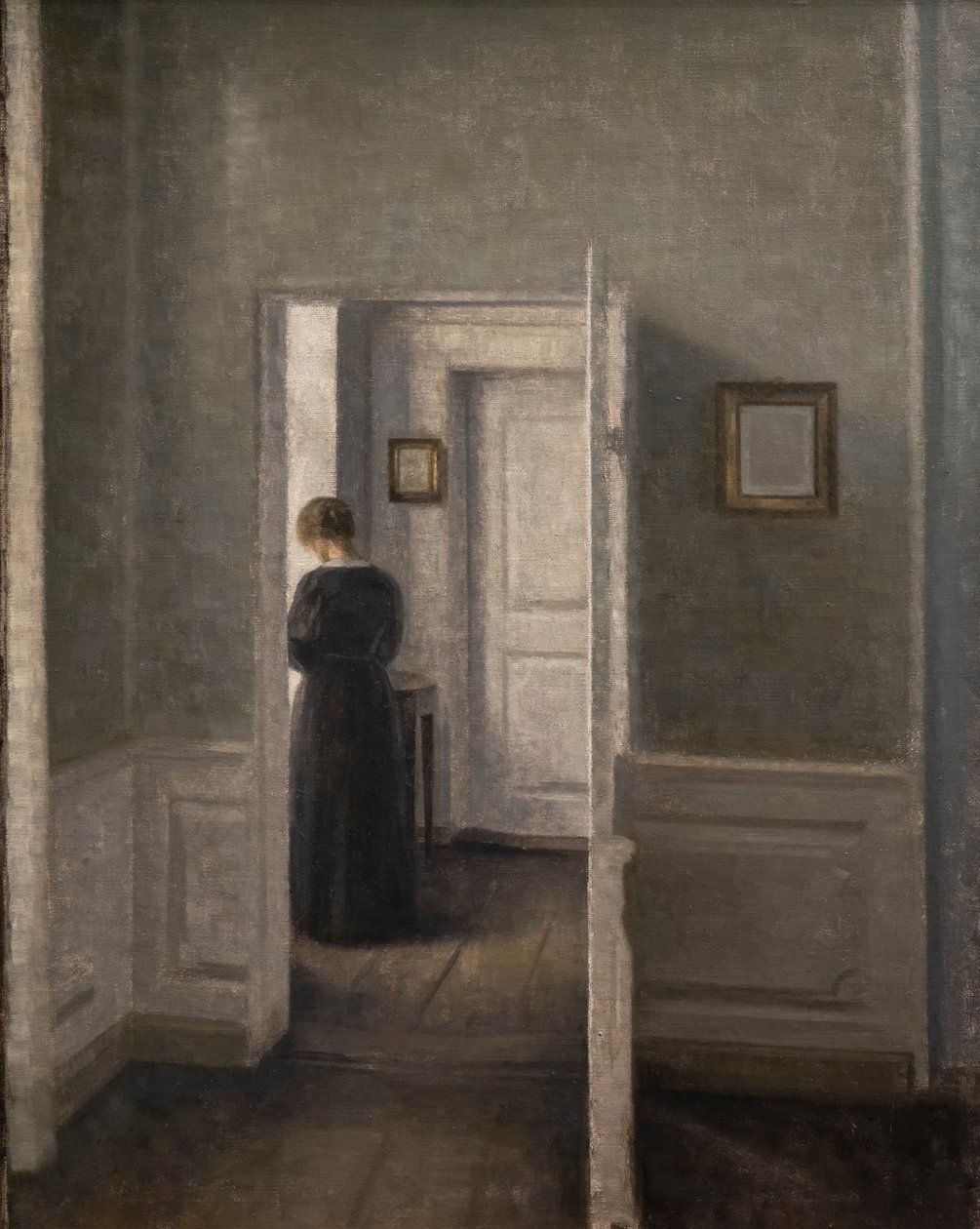 Interieur met een staande vrouw door Vilhelm Hammershoi