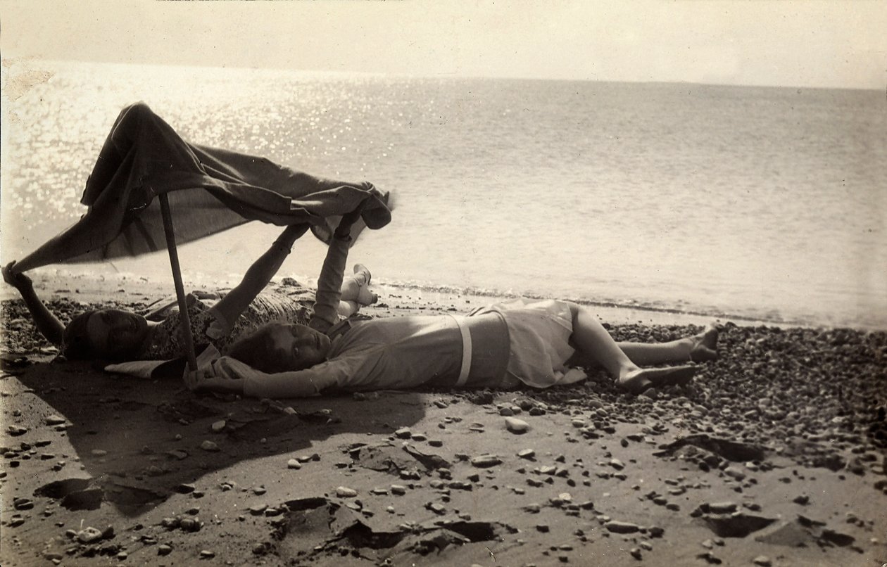 Twee vrouwen liggen aan zee in de schaduw van een handdoek. Briefkaart gestuurd door de fotograaf naar Vincenzo Balocchi door Vincenzo Balocchi