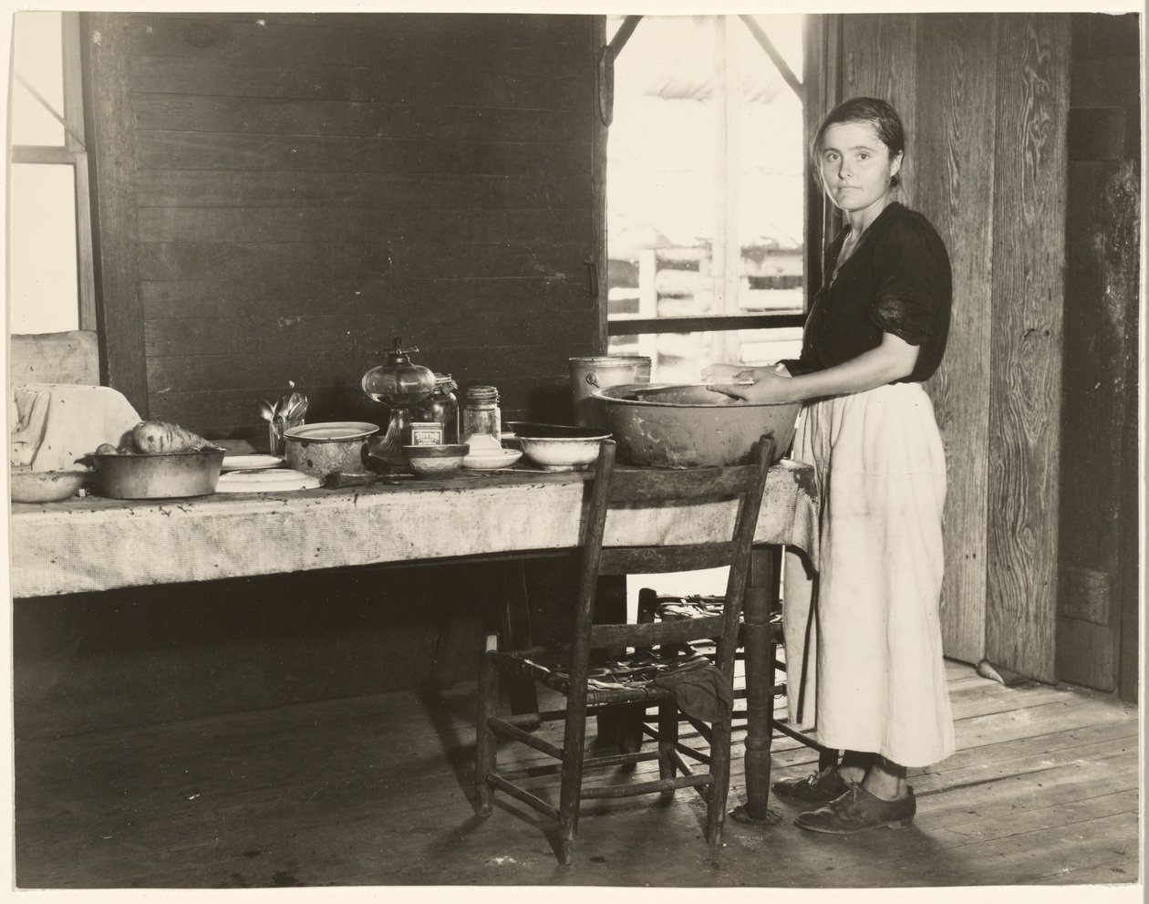[Elizabeth Tengle aan de keukentafel]/[Paralee Ricketts aan het werk in de keuken]. door Walker Evans