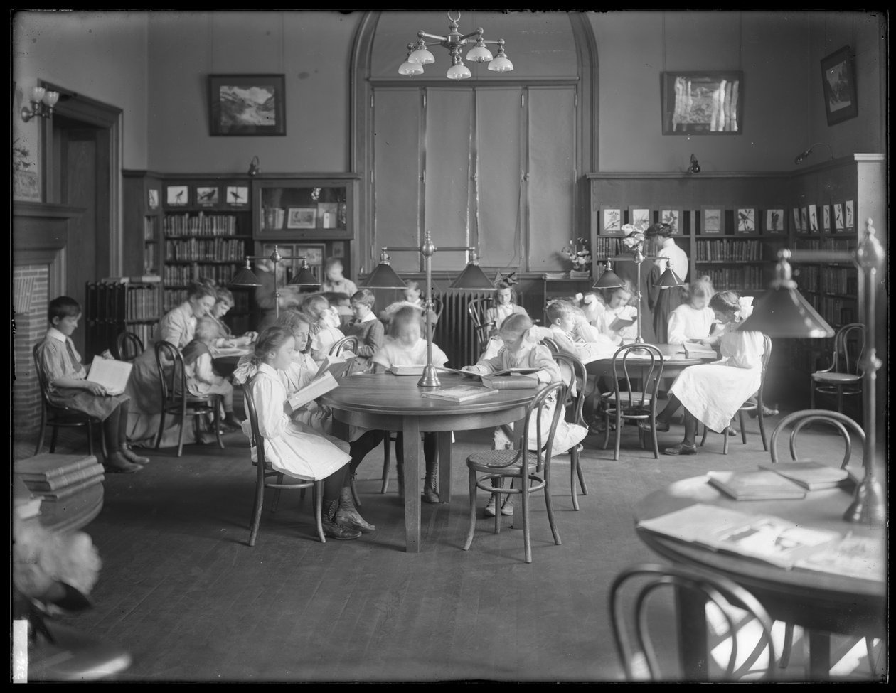 Kinderen lezen in de leeszaal van een niet-geïdentificeerde vestiging van de Queens Borough Public Library, ca. 1910 door William Davis Hassler