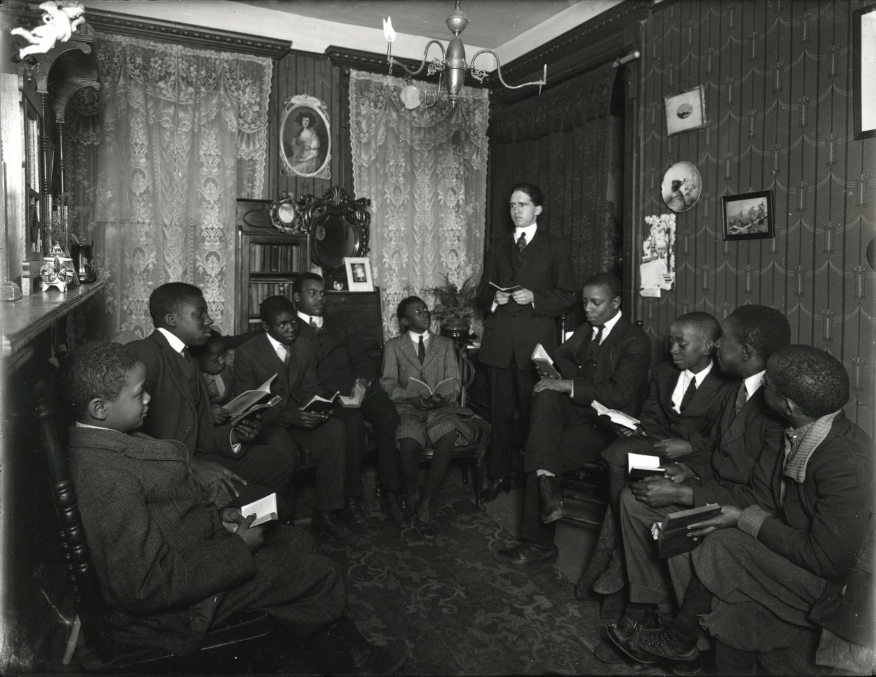 Evangelistencomitéles bij mevrouw Bostick, 72 West 99th Street, de heer Rockwood geeft les aan een groep jonge Afro-Amerikaanse mannen en jongens. 31 maart 1916 door William Davis Hassler