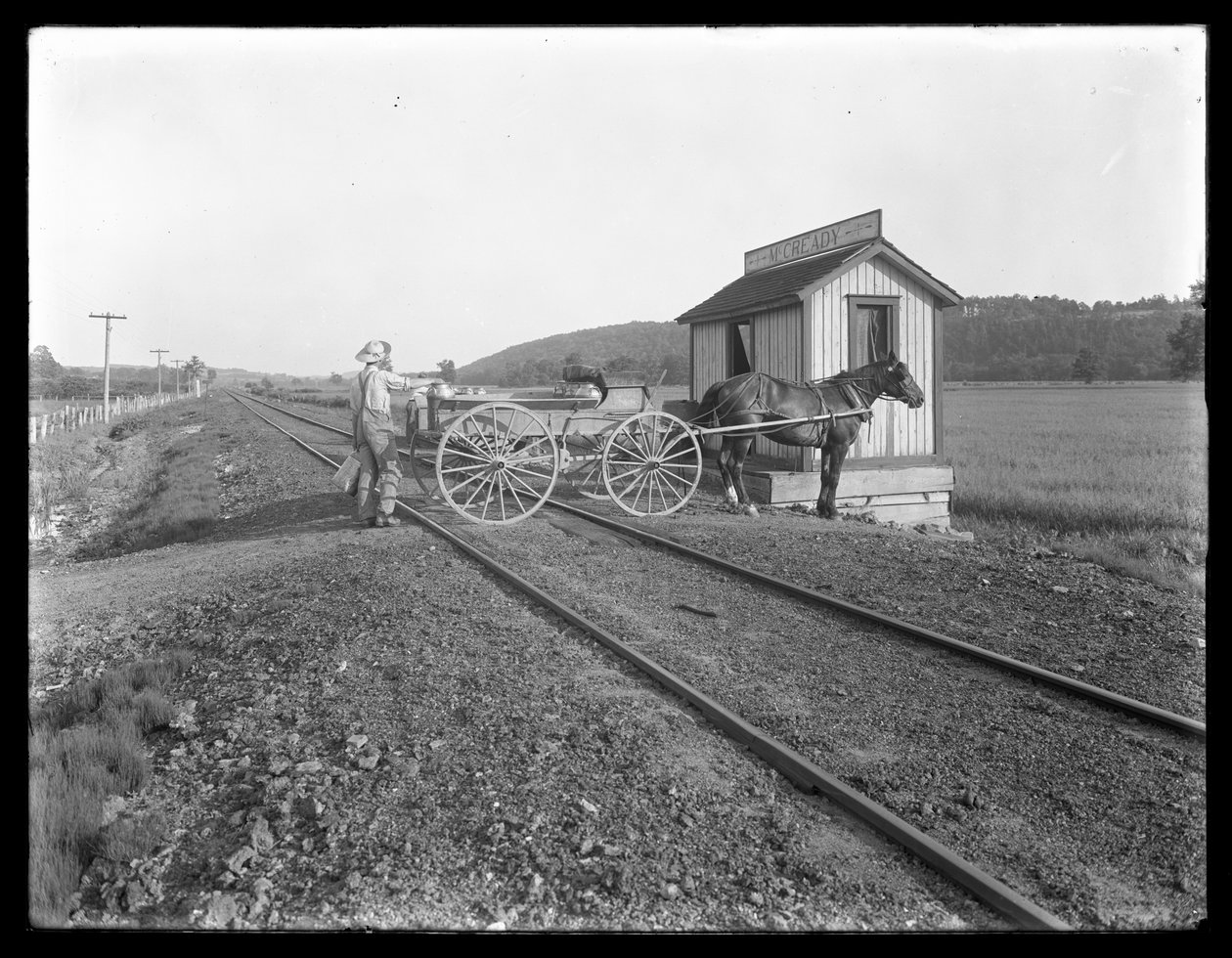 Onbekende man laadt melk op een paard-en-wagen geparkeerd over spoorrails buiten de McCready-boerderij, Pennsylvania, c.1913 door William Davis Hassler