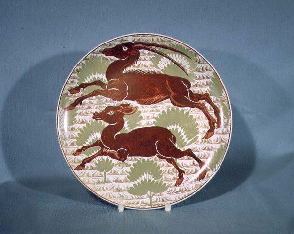 Bord versierd met twee rennende antilopen in robijnrood glazuur op crèmekleurig aardewerk, eind 19e eeuw door William de Morgan
