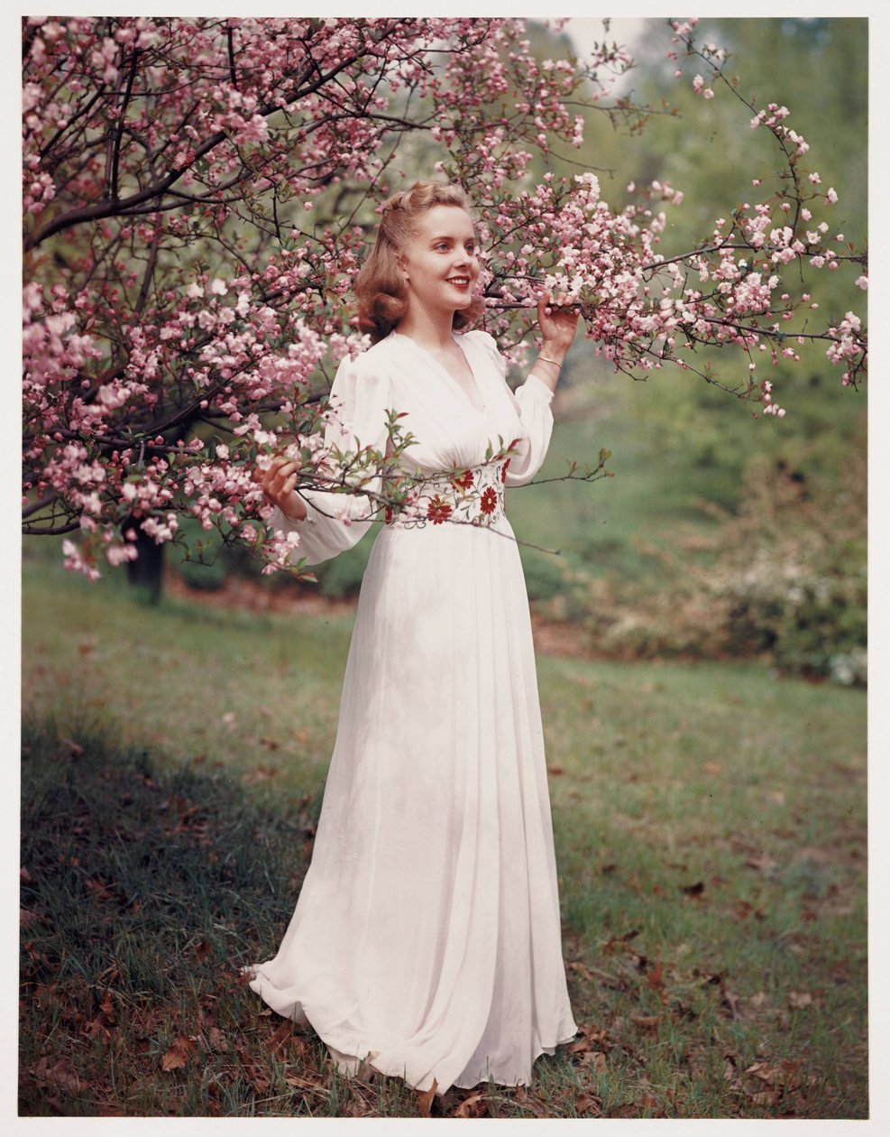 Vrouw die een jurk modelleert bij bloesem, ca. 1940s door Frederick (attr. to) Barnard