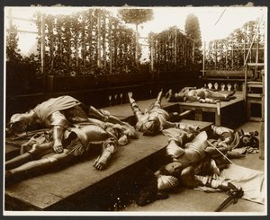 [Zes mannelijke modellen als oude krijgers gekleed in harnas die doen alsof ze dood zijn]. door Alphonse Maria Mucha