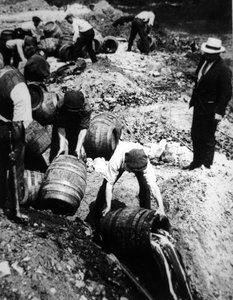 Een Amerikaanse federale agent houdt toezicht op de vernietiging van biervaten tijdens het Amerikaanse droogleggingstijdperk (1920-33)