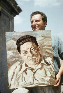De Italiaanse schilder en schrijver Carlo Levi (1902-1975) met een van zijn werken in de hand, een portret van de vakbondsman Giuseppe di Vittorio (foto) door Ando Gilardi