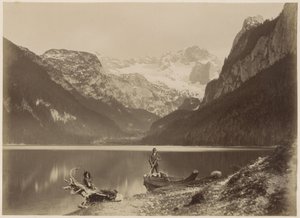 Gezicht op een meer en omliggende bergen met op de voorgrond een man staand in een boot, vermoedelijk in de Alpen