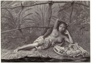 Portret van een onbekende Indonesische halfnaakte vrouw, liggend met een fruitmand in een decor door Anonymous