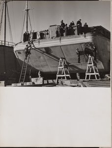 [Een groep mannen werkt aan een aangemeerde boot]. door Arnold Eagle
