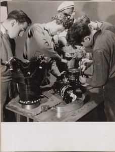 [Vijf jonge mannen werken rond een werkbank]. door Arnold Eagle
