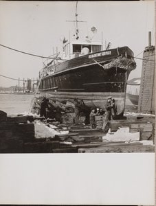 [Vier mannen repareren de onderste helft van een aangemeerde boot]. door Arnold Eagle