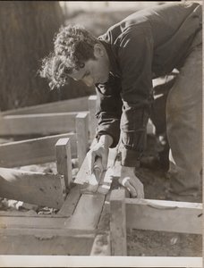 [Metselaar strijkt cement glad tijdens het storten van een fundering].