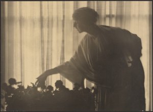 [Vrouw die bloemen verzorgt in haar appartement]. door Arthur F. Kales