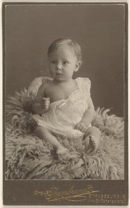 [Ongeïdentificeerde baby zittend op een lamsvel tapijt].