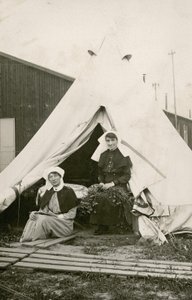 Zuster Eleanor Wibmer Jeffries en zuster Nellie Constance Morrice (rechts) buiten hun tent bij het 3e Australische Algemeen Ziekenhuis met bloemen geplukt van de oever van de Somme, c. juni 1917 door Australian Photographer