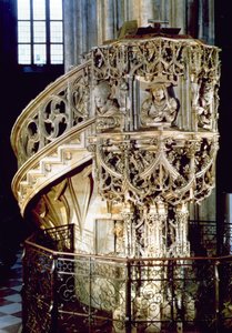 Pelgrims preekstoel, versierd met bustes van de vier kerkvaders, theologen die de vier fysiognomische temperamenten vertegenwoordigen, de beeldhouwer zelf kijkt uit een raam beneden, door Anton Pilgr