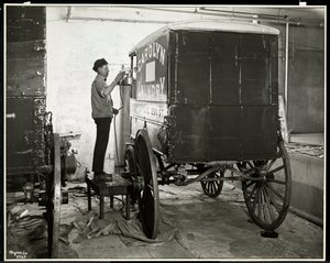 Een man die een bezorgwagen van de Carolyn Laundry spuitverft op 111 East 128th Street, East Harlem, New York, 1929 door Byron Company