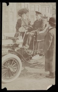 Hattie Williams zittend met chauffeur in een van de eerste auto