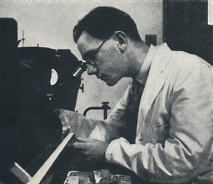 Onderzoeker met microscoop test de structuur van een aluminiumlegering, 1941
