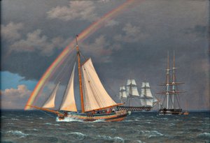 Regenboog op zee met enkele varende schepen