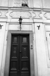 Jiri Mucha laat een sleutel aan een touw zakken zodat een bezoeker de deuren van zijn huis in Hradcany, Praag kan openen