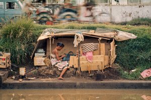Kartonhut langs een rioolkanaal, dient als huis. Jakarta, Indonesië