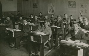 Mannelijke leerlingen zitten achter hun bureaus tijdens een les op school