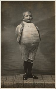 Schooljongen, verkleed om een zeer grote buik te hebben door English Photographer