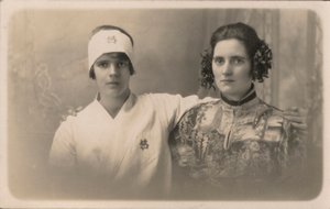 Twee jonge vrouwen, met armen om elkaars schouders door English Photographer