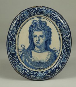 Een Delfts blauw en wit ovaal koninklijk portretplaquette van Koningin Anne, waarschijnlijk Londen, ca. 1705 door English School