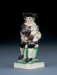 Dick Whittington jug, gemodelleerd zittend op een hoge stoel, zijn kat vasthoudend, gespat in bruine, groene en zwarte kleding, een gemodelleerd schild aan zijn zijde, c.1790 door English School