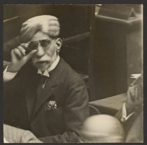 [Zittende man met tulband en donkere bril].