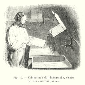 Zwarte kamer van de fotograaf, verlicht door gele ruiten (gravure)