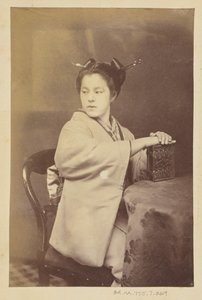 [Zittende Japanse vrouw die een cartes-de-visite album vasthoudt aan een tafel].