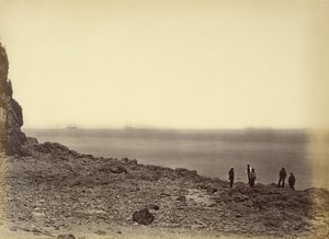 [Zicht op kust met schepen aan horizon en vijf figuren staand op strand]. door Felice Beato