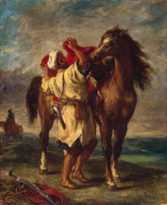 Arabier die zijn paard zadelt
