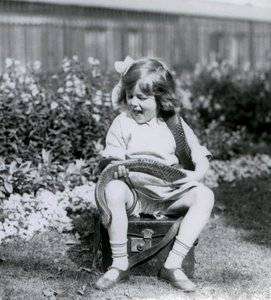 Een jong meisje Betty houdt een oostelijke indigo-slang vast terwijl ze op een leren koffer zit, London Zoo, 1924