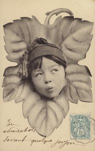 Gezicht van een kleine jongen in het midden van een blad