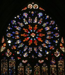 Raam w135 met God, serafijnen, muzikale engelen en tien van de apostelen. De lancetten hieronder bevatten laat 16e-eeuwse figuren, de patroonheiligen van de toenmalige kanunniken: St. Jacobus, St. Christoffel, St. Karel de Grote door French School