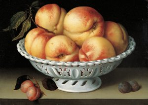 Perziken in een geperforeerde witte faience mand