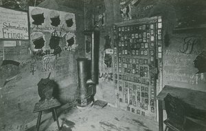 Een kamer met muren bedekt met graffiti verwijzend naar belangrijke hedendaagse figuren zoals Bussche en Waldow. Ansichtkaart verzonden in 1913. door German Photographer