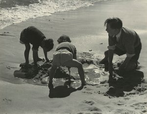 Drie kinderen spelen met zand op het strand