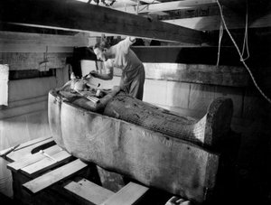 Ontdekking van het graf van farao Toetanchamon in de Vallei der Koningen (Egypte): in de grafkamer, Howard Carter werkt aan het deksel van de tweede kist, oktober 1925, foto door Harry Burton door Harry Burton
