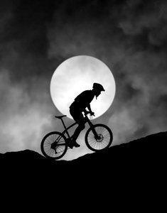 Mountainbiker bij maanlicht