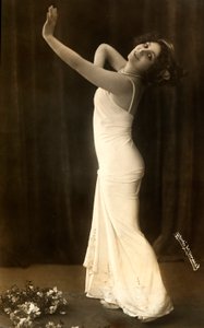 Portret van de Franse actrice Regina Badet in een evocatieve pose, gekleed in een lange witte jurk