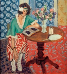 Lezende vrouw aan een tafel (in groen, rood gestreepte jurk) door Henri Matisse