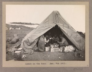 Vier expeditieleden lunchen in een tent door Herbert Ponting