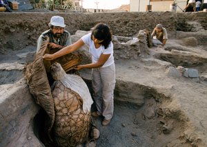 Archeologen met een mummiebundel gevonden op de opgravingslocatie van de school., 2001 (foto)
