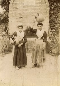 Twee jonge vrouwen in traditionele kleding met terracotta kruiken bij waterput, Marche, Italië, ca 1910 door Italian Photographer